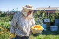 Beekeeper is holds honey in honeycombs on the apiary. Beekeeper on apiary.