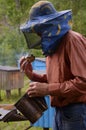 Beekeeper preparing a smoker for fumigating bees