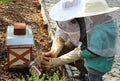 Beekeeper teaching a little boy how to produce smoke to calm bees