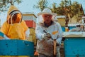 Beekeepers checking honey on the beehive frame in the field. Small business owners on apiary. Natural healthy food