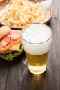 Beer being poured into glass with gourmet hamburgers and french Royalty Free Stock Photo