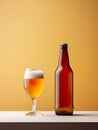 Beer bottle alongside a glass filled with refreshing beer, set against a vibrant yellow background. Royalty Free Stock Photo
