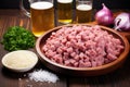 beer bottle, diced onions, and a plate of sausages: preparation scene