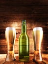 Beer bottle with a glass full of beer on the table. The background Aged board. Royalty Free Stock Photo