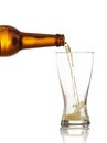 Beer bottle pouring beer in a glass, white background, closeup view Royalty Free Stock Photo