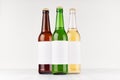 Beer bottles 500ml different colors with blank white label on white wooden board, mock up. Template for advertising, design, brand Royalty Free Stock Photo