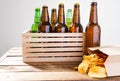 Beer bottles and potato chips on a wooden table. Top view. Selective focus. Mock up. Copy space.Template. Blank.