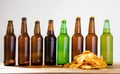Beer bottles and potato chips on a wooden table. Top view. Selective focus. Mock up. Copy space.Template. Blank.