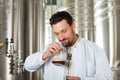 Beer brewer in his brewery examining