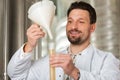 Beer brewer in his brewery examining