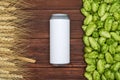 A beer can, green cones of hops and grain on wooden background. Top view. Free space for text Royalty Free Stock Photo