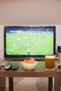Beer, chips and remote controls on the table