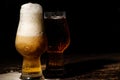 Beer. Cold Craft light Beer in a glass with water drops on the wooden table over the black background Royalty Free Stock Photo