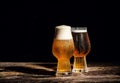 Beer. Cold Craft light Beer in a glass with water drops on the wooden table over the black background Royalty Free Stock Photo