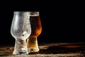 Beer. Cold Craft light Beer in a glass with water drops on the wooden table over the black background Royalty Free Stock Photo