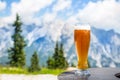 Beer. Cold golden draft beer in glass over alps. Tasty beer and tourist season in the mountains or the Alps
