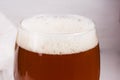 Beer foam in glass of home made craft beer and bag of light malt on white background. Craft beer brewing from grain barley pale