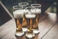 Beer with foam light tall boys standing on a wooden table closeup Royalty Free Stock Photo