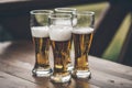 Beer with foam light tall boys standing on a wooden table closeup Royalty Free Stock Photo