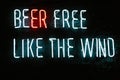 beer free like the wind neon inscription on dark wall in bar