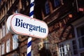 Beer garden sign. Opened shield in german biergarten on a sunny holiday. Old traditional german buildung in background