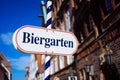 Beer garden sign. Opened shield in german biergarten on a sunny holiday. Old traditional buildung and blue sky in