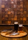 Beer glass with beer on a background of dried fish on a wooden table in a rustic style