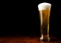 Beer and glass on a black and wooden table Royalty Free Stock Photo