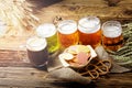 Beer glass and old vintage beer barrel with wheat on wooden table in a alcohol cellar. Beers prepared in various colours on board