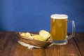 Beer glass with beer and smoked fish close-up. Beer mug with beer and potato chips, crackers on a wood background and copy space Royalty Free Stock Photo