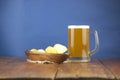 Beer glass with beer and smoked fish close-up. Beer mug with beer and potato chips, crackers on a wood background and copy space Royalty Free Stock Photo