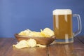 Beer glass with beer and smoked fish close-up. Beer mug with beer and potato chips, crackers on a wood background and copy space Royalty Free Stock Photo