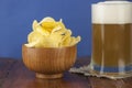 Beer glass with beer and smoked fish close-up. Beer mug with beer and potato chips, crackers on a wood background and copy space Royalty Free Stock Photo