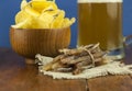 Beer glass with beer and smoked fish close-up. Beer mug with beer and potato chips, crackers on a wood background and copy space Royalty Free Stock Photo