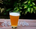 Beer in glass on wood table with ice, car background. Royalty Free Stock Photo