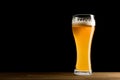 Beer in glass, wooden table, isolated on black background Royalty Free Stock Photo