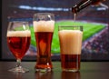 Beer glasses in front of tv, football at home Royalty Free Stock Photo