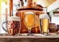 Beer glasses on wooden table and copper brewing cask at the background. Craft brewery Royalty Free Stock Photo