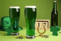 Beer, gold and St Patrick`s Day decor on green background