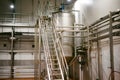 Beer manufacture line. Equipment for staged production bottling of Finished food products. Metal structures, pipes and tanks at en Royalty Free Stock Photo