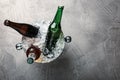 Beer in metal bucket with ice on grey table. Space for text