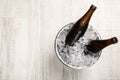 Beer in metal bucket with ice on white wooden table, top view. Space for text Royalty Free Stock Photo