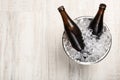 Beer in metal bucket with ice on white table, top view. Space for text Royalty Free Stock Photo
