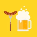 Beer mug with foam and sausage on a barbecue fork.