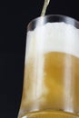 Beer pouring into a sweated mug on dark background