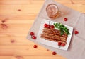 Beer mug and plate with roasted sausages, cherry tomatoes and parsley on wooden table. Royalty Free Stock Photo