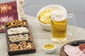 A beer mug with snacks around