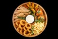 beer plate fried ribs onion rings french fries fish nuggets on a wooden plate on a black background1