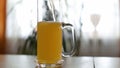 Beer is poured to half empty mug on table