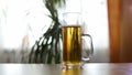 Beer is poured to half empty mug on table